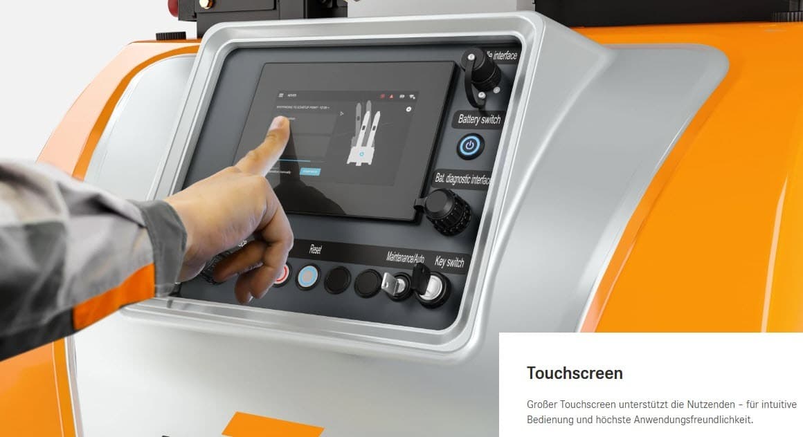 Ein Mitarbeiter bedient einen Touchscreen auf einer industriellen Schalttafel, die von Tasten und Reglern umgeben ist, und steuert damit Logistikprozesse.
