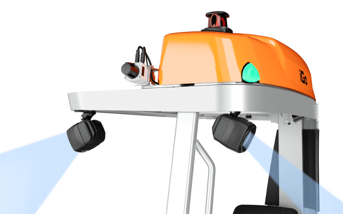 Nahaufnahme eines orangefarbenen automatisierten Gabelstaplers, der mit Kameras und Sensoren ausgestattet ist, die blaue Lichter projizieren, um die Navigation in einer geschäftigen Lagerumgebung zu erleichtern.