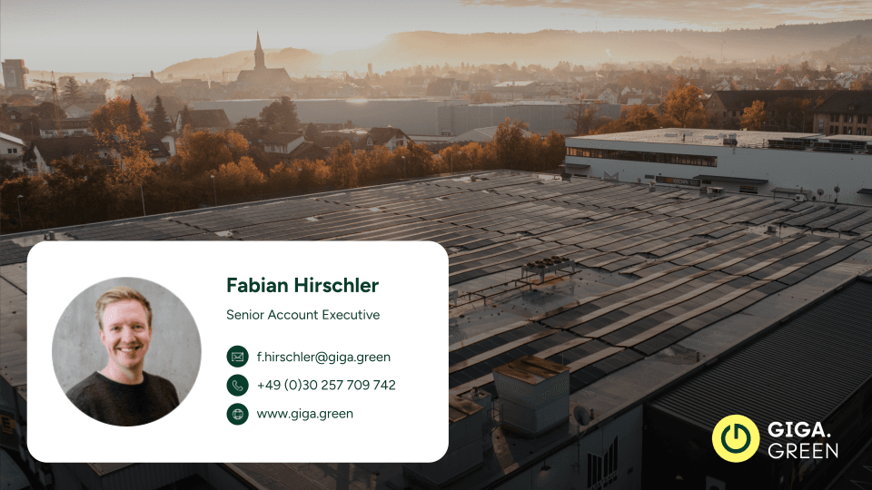 Aerial view of a rooftop with solar panels under a hazy sky. The foreground features an inset with a portrait of a man smiling, alongside his contact details, and the GIGA.GREEN logo.