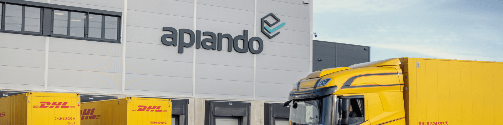 Apiando logistics center with yellow DHL trucks at the loading docks